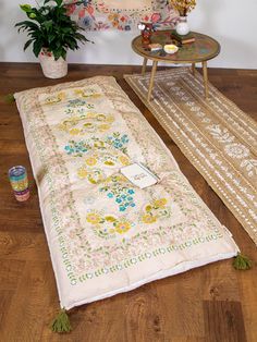 a table and rug on the floor next to a potted plant with candles in it