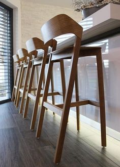 a row of bar stools in front of a window