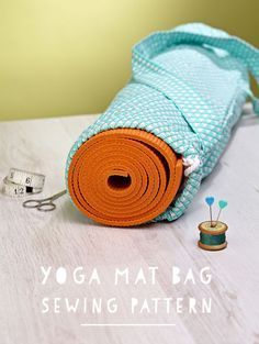 an orange yoga mat bag sitting on top of a table next to a sewing needle