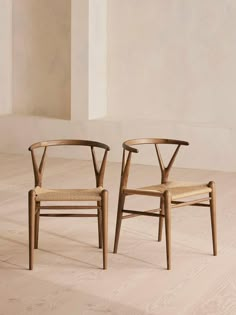 two wooden chairs sitting next to each other