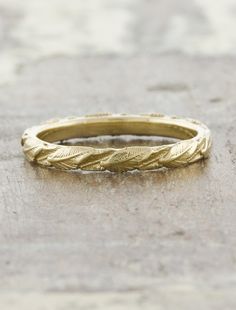 a yellow gold wedding band on concrete