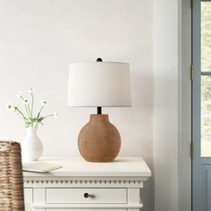 a table with a lamp and vase on it