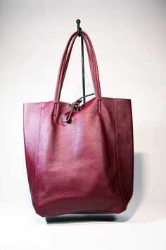 A lightweight and spacious Leather Shopper Tote Bag-Burgundy you can use for your office, gym and after-hours essentials while still looking stylish. Handmade from supple calfskin leather, the versatile look features over-the-shoulder handles and minimal detailing. Raw edges and no lining makes this style super light and easy to fold when traveling. Inside is a zippered document pouch and a leather cell phone pouch. Details: Color: BurgundyTwo leather strap for closing the bag.Natural unlined in Classic Large Capacity Burgundy Shoulder Bag, Modern Burgundy Bag With Double Handle, Versatile Burgundy Satchel Bag, Burgundy Leather Satchel With Leather Handles, Burgundy Shoulder Bag With Leather Lining, Burgundy Soft Leather Bag With Double Handle, Chic Burgundy Bag With Leather Lining, Classic Burgundy Satchel With Large Capacity, Classic Large Capacity Burgundy Bag