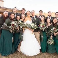 a group of people standing next to each other in front of a building holding bouquets