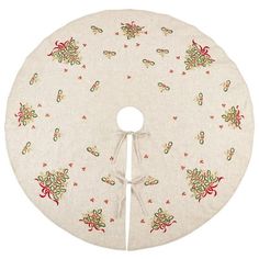 a white round table cloth with red and green flowers on it