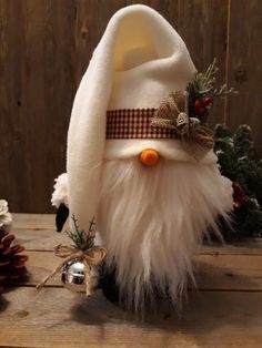 a white stuffed animal with a bow on it's head sitting next to christmas decorations