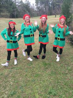 four girls dressed in green and red are posing for the camera with their hands out