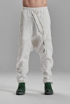 "DISTORTED BOILED LINEN DROPPED CROTCH TROUSERS WITH ELASTIC WAISTBAND__ These contemporary boiled linen trousers are created to escape the mainstream similarly. A distorted front is offset by two irregular pockets on the back, asymmetrically positioned on different levels, and J shaped, arched legs, cause the pants to stay very bunched up, embodying the most brutally urban and masculine silhouette__ who__ Conceptual Thinker when__ Cool Evenings where__ From The Studio To An Underground Party mo White Full Length Pants With Belt Loops, Baggy White Parachute Pants With Pockets, White Baggy Parachute Pants With Pockets, White Linen Straight Pants, White Full-length Bottoms With Belt Loops, Summer White Pants With Belt Loops, White Summer Pants With Belt Loops, White Baggy Full-length Parachute Pants, White Straight Pants With Belt Loops