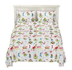 a bed with christmas themed sheets and pillows