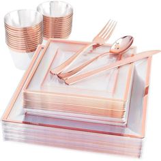 a set of pink and gold dinnerware with forks, spoons and napkins