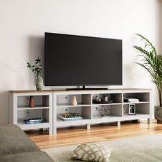 a flat screen tv sitting on top of a white entertainment center in a living room