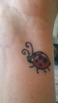 a lady bug tattoo on the wrist