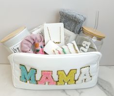 a white basket filled with personalized items on top of a marble counter next to a wall