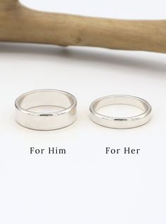 two silver wedding rings sitting next to each other