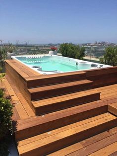 an above ground pool with steps leading up to it and a hot tub in the middle