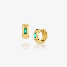 14k gold huggie earrings featuring emeralds in bezel settings adding a hint of sophictication to your ears. 14k Gold Bezel Set Huggie Earrings For Anniversary, Fine Jewelry Huggie Earrings With Bezel Setting For Gifts, 14k Gold Bezel Set Huggie Earrings, 14k Gold Huggie Earrings With Bezel Setting, Elegant Emerald Huggie Hoop Earrings, Classic Bezel Setting Huggie Earrings, 14k Gold Huggie Earrings With Gemstone, Green 14k Gold Huggie Earrings Gift, Yellow Gold Emerald Huggie Earrings