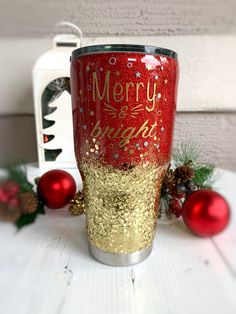 a red and gold christmas cup sitting on top of a white table