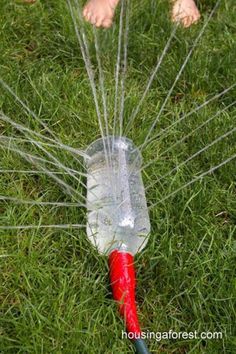 a plastic bottle that has been sprinkled with water on top of some grass