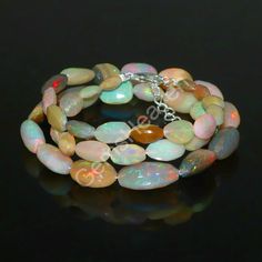 a bracelet made with opalite beads and silver findings on a black background photo