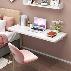 a laptop computer sitting on top of a white desk next to a pink chair and bed