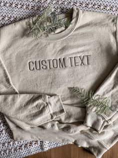 "CUSTOM TEXT EMBROIDERED APPAREL ♡ Gildan 18000 Heavy Blend Crewneck Sweatshirt T - Unisex ♡ Custom Text ♡ 100% Pre-Shrunk Cotton ♡ 40/50 Cotton/Polyester ♡ Made in the U.S. ♡ Model is wearing \"Sand\"; Size: S; Embroidery Thread: \"Brown\" IMPORTANT NOTICE: Crewnecks now have a paper like stabilizer that appears on the inside. This helps with increasing quality and ensure a longer lasting design on the sweatshirts. NOTE: Personalization will appear exactly as typed. Please ensure that all capit Basic Relaxed Fit Top With Custom Embroidery, Basic Cotton Tops With Custom Embroidery And Relaxed Fit, Basic Crew Neck Tops With Letter Embroidery, Cotton Crew Top With Custom Text, Cotton Crew Neck Tops With Custom Text, Brown Embroidery, Embroidered Apparel, Letter Sweatshirt, Embroidered Crewneck