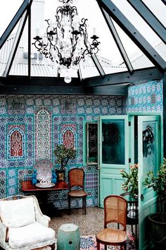 a living room filled with furniture and a chandelier hanging over the top of it