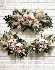 two floral wreaths hanging on a brick wall