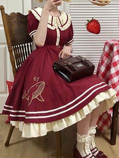 a woman in a red dress sitting on a chair holding a cell phone to her ear