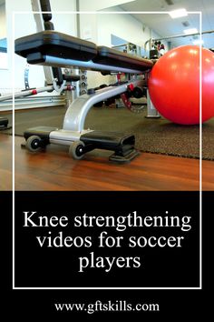 a red ball sitting on top of a wooden floor next to a gym equipment rack