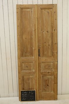 an old pair of wooden doors with chalkboard on the bottom and bottom, in front of a white wall