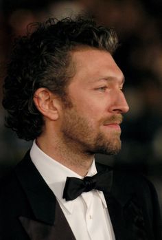 a close up of a person wearing a tuxedo and looking off to the side