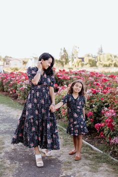 Complete your dress collection with this show-stopping Sienna Dress. This gorgeous black dress features a romantic, pink floral pattern that perfectly contrasts fun white polka dots, allowing you to embrace every side of yourself. Plus, it's available in a mini size, so you and your daughter can match for a picture-perfect moment you'll never forget STYLE INFO & CARE Tiered Skirt Smocked Waist Fully Lined 100%  Polyester  Machine Washable in cold water, or for best results dry clean Black Summer Dress For Garden Party, Flowy Black Maxi Dress In Feminine Style, Black Flowy Feminine Maxi Dress, Fitted Black Floral Maxi Dress, Black Floral Print Maxi Dress For Wedding, Black Floral Print Dress For Wedding, Black Floral Print Wedding Dress, Feminine Black Short Sleeve Dress, Black Floral Maxi Dress For Garden Party