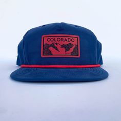 Everyone loves a good, comfy hat. How about one with a little bit of flair that helps you rep your favorite state?! Ooohhh yeah, we have our Colorado mountains patch now in red on a navy five panel rope hat! Grab your today for your next mountain adventure! Moisture wicking with UPF 50+ tech. One size. Adjustable. Flat Bill Snapback Hat For Hiking, Navy Trucker Hat With Flat Brim For Outdoor, Blue Snapback Hat For Hiking, Red Snapback Hat With Curved Bill For Outdoor, Red 5-panel Hat For Outdoor, Adjustable Blue Baseball Cap For Camping, Blue Adjustable Trucker Hat For Camping, Adjustable Blue Hats For Hiking, Red Adjustable Snapback Hat For Outdoor Activities