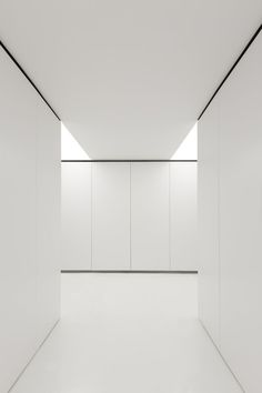 an empty room with white walls and floor