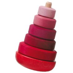 a stack of red and pink wooden toys on a white background with space for text