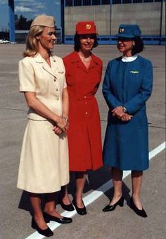 three women standing next to each other in front of an airport tarmac and building