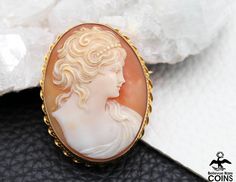 Metal: 10k Yellow Gold (.417) Weight: 10.3 grams Measurements: 1.7" Long; 1.3" Wide; 0.5" Deep Shell: Carnelian Markings: 10K *Delicately hand-carved, this beautiful carnelian shell cameo brooch features an image of a beautiful lady facing right with pearl hoop in hair. The cameo of the woman is set into an intricate 10k yellow gold bezel. This outstanding Victorian cameo is in great condition, with light wear. The safety clasp works nicely. The stunningly bright carving gives the brooch that ex Cameo Brooches For Wedding, Classic Oval Brooches, Oval Brooches For Formal Occasions, Collectible Cabochon Brooches, Anniversary Oval Brooches, Vintage Gemstone Brooches, Victorian Cameo, Gold Border, Carved Shell