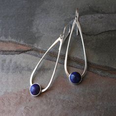 Lapis Lazuli teardrop dangle earrings. 8mm deep blue lapis set in sterling silver on handmade sterling silver teardrops. The teardrops swing from solid sterling silver ear wires. These earrings are 2 1/4 inches long including the ear wires. 5/8 inches at the widest part of the teardrop. For more Modern Adjustable Drop Jewelry, Modern Nickel-free Drop Jewelry, Modern Drop Matching Earrings Jewelry, Modern Nickel-free Teardrop Pendant Jewelry, Modern Teardrop Sterling Silver Earrings, Pierced Teardrop Pendant Jewelry For Gift, Modern Long Drop Teardrop Earrings Gift, Modern Hypoallergenic Drop Jewelry, Modern Sterling Silver Teardrop Jewelry