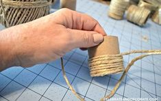 a person is holding a rope and making something out of twine on the table