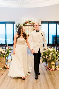 a bride and groom walking down the aisle at their wedding ceremony in an indoor venue