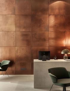 two chairs and a table in front of a wall with copper colored tiles on it