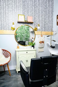 a chair and mirror in a room with patterned wallpaper on the walls behind it