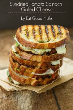 grilled tomato and spinach sandwich stacked on top of each other with text overlay that reads, sun dried tomato spinach grilled cheese by eat good 4 life