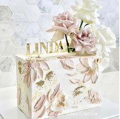 a white box with pink flowers and the word india written in gold letters on it