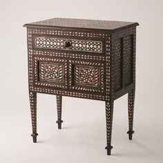 Precisely inlaid mother of pearl in a melange of traditional Rajasthani patterns gives the Bhawana nightstand loads of charm. The nightstand sits upon delicately tapered legs with spade foot detail. One drawer and double bottom doors provide good storage. Dimensions Overall 24"W x 30"H x 15"D (32.78 lbs) Drawer 18.75"L x 10.5"W x 2"H Doors 20.25"L x 11.75"W x 8"H  Teak Medium Wax Stain To achieve a longer finish, periodical use of clear furniture wax is recommended with a dry cloth Designer Nightstand, Bone Inlay Side Table, Nightstand Light, Bone Inlay Furniture, Inlay Furniture, Wood Bedside Table, Furniture Wax, Global Views, Teak Frame