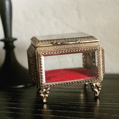 a small mirror sitting on top of a wooden table next to a black candle holder