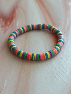 a multicolored beaded bracelet sitting on top of a bed