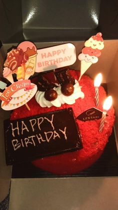 a birthday cake in a box with candles