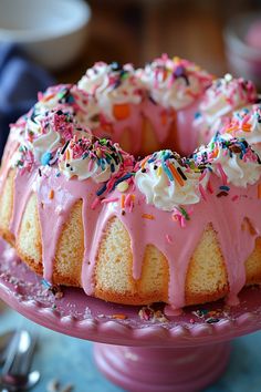 Bundt cake with pink frosting, whipped cream, and colorful sprinkles on a pink cake stand. Bundt Cake Recipes Uk, Bundt Birthday Cake Ideas, Bundtinis Recipe, Bundt Cake Recipes Easy, Stuffed Bundt Cake, Bundt Cake Decorating, Copycat Nothing Bundt Cake, Decorated Bundt Cakes, Bundt Cake Ideas