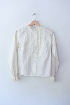 button up ruffle bib blouse  era: 1960's label: Mardi Modes New York size: s material: cotton condition: excellent ---- facebook  :  heir sundries instagram  :  @heirsundries https://www.heirsundries.com White Ruffle Blouse, Ruffled Blouse, Button Up Top, Long Blouse, Vintage 1960s, Antique Style, Vintage Stil, Womens Clothing Tops, Blouses For Women